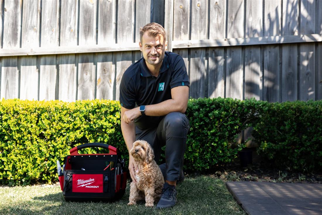 Alan's Local Plumbing plumber with his tool bag and a friendly dog outside a Sydney home