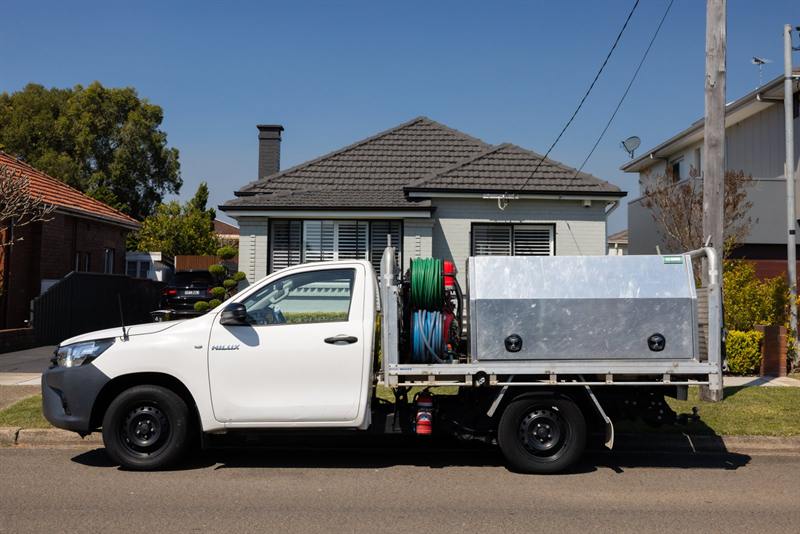 Alan's Local Plumbing service ute outside a Sydney home
